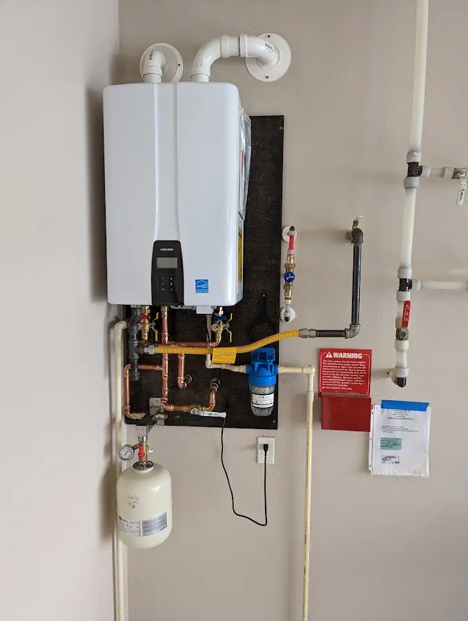 Professional plumber installing copper piping in a Newington home